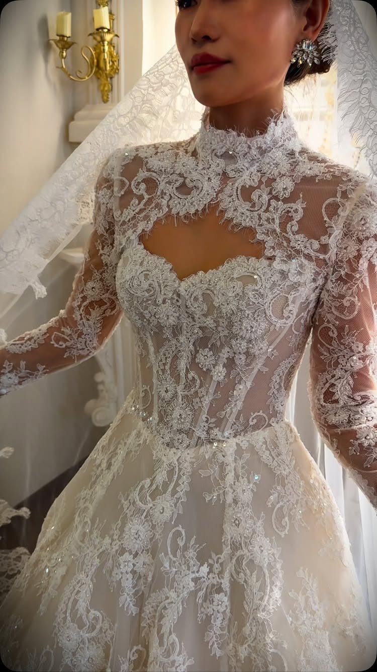 Tight Lace Wedding Dresses in 25 Beautiful Styles 3 Woman in a white long-sleeve lace wedding dress with a full A-line skirt.