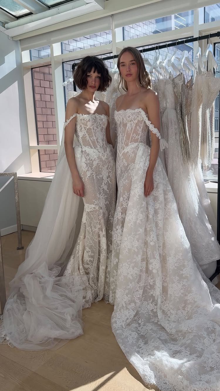Tight Lace Wedding Dresses in 25 Beautiful Styles 5 Two women wearing white off-the-shoulder lace wedding dresses in a bright bridal boutique.