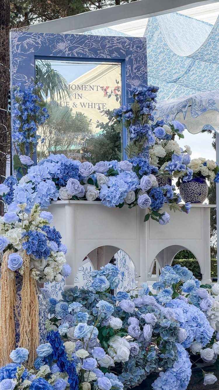 Wedding Flower Trends: 36 Ideas from Jewel Tones to Arches 10 Blue and white floral arrangements decorating a white structure under a white canopy.