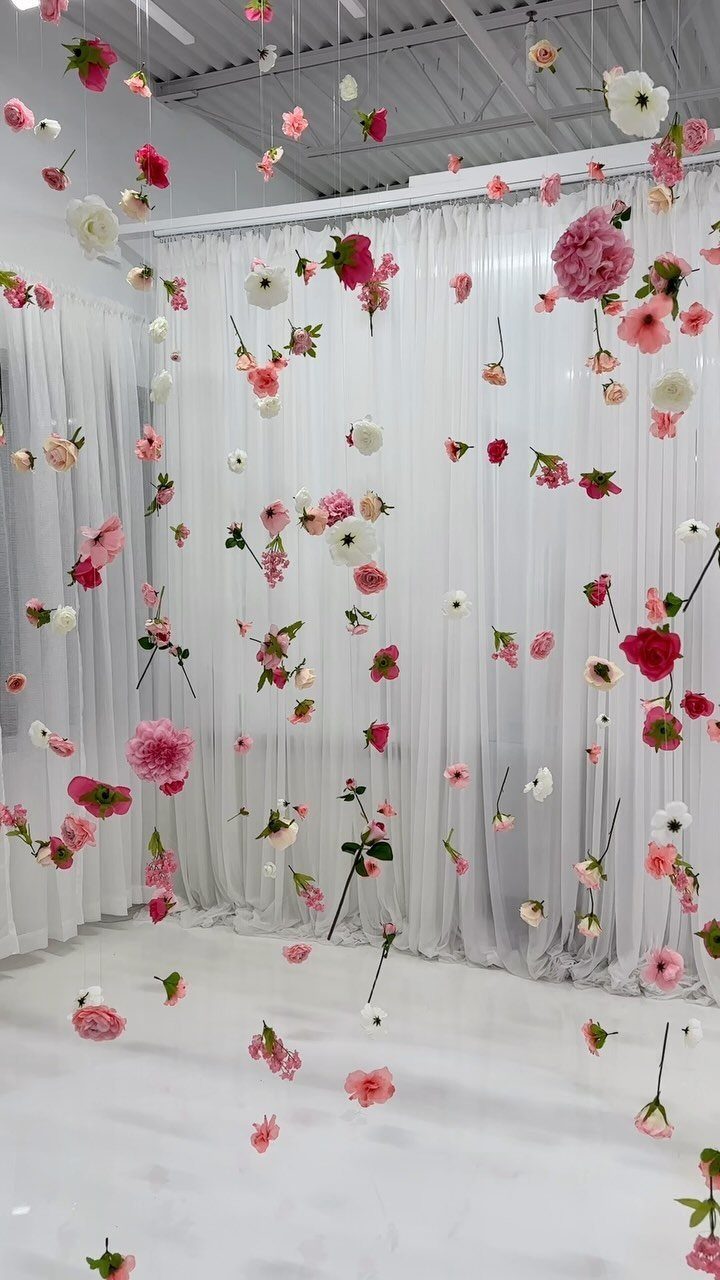 Wedding Flower Trends: 36 Ideas from Jewel Tones to Arches 33 Floating pink and white flowers suspended in front of a white curtain backdrop.