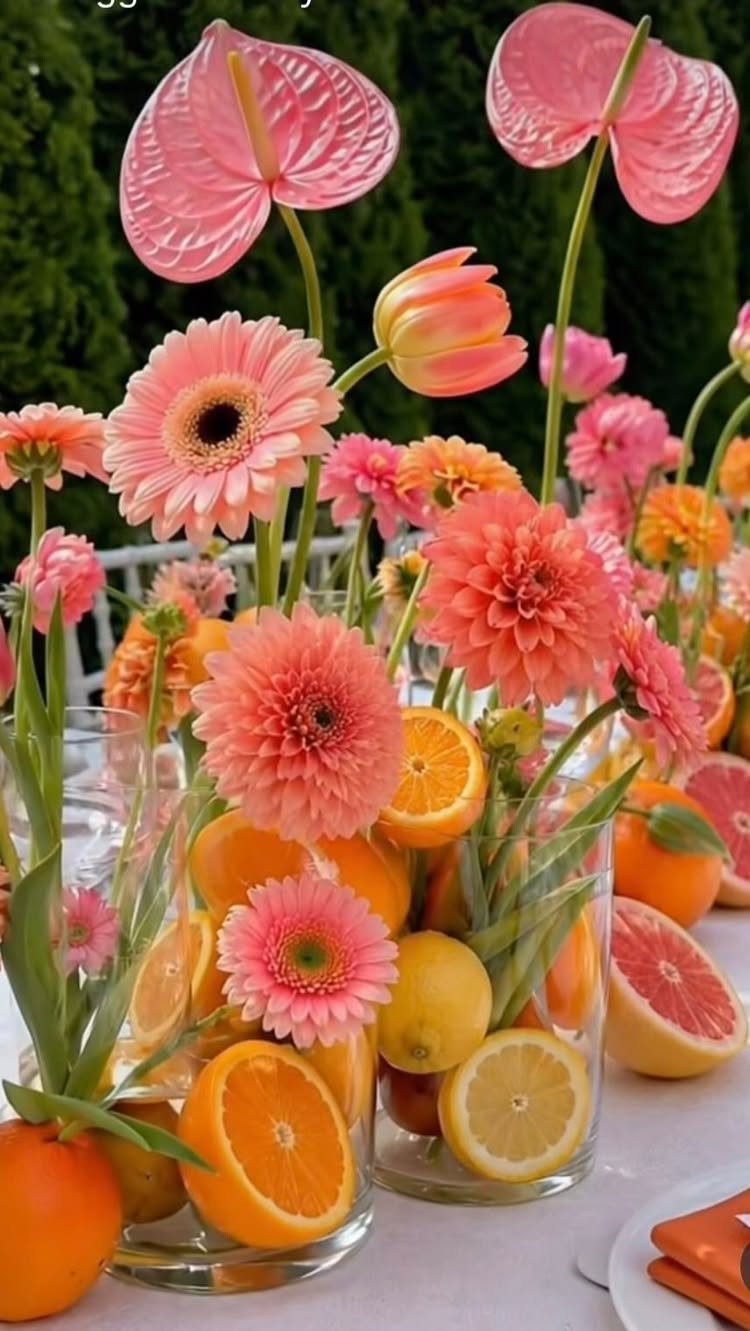 Wedding Flower Trends: 36 Ideas from Jewel Tones to Arches 17 Pink flowers and citrus fruits arranged in glass vases on a wedding table.