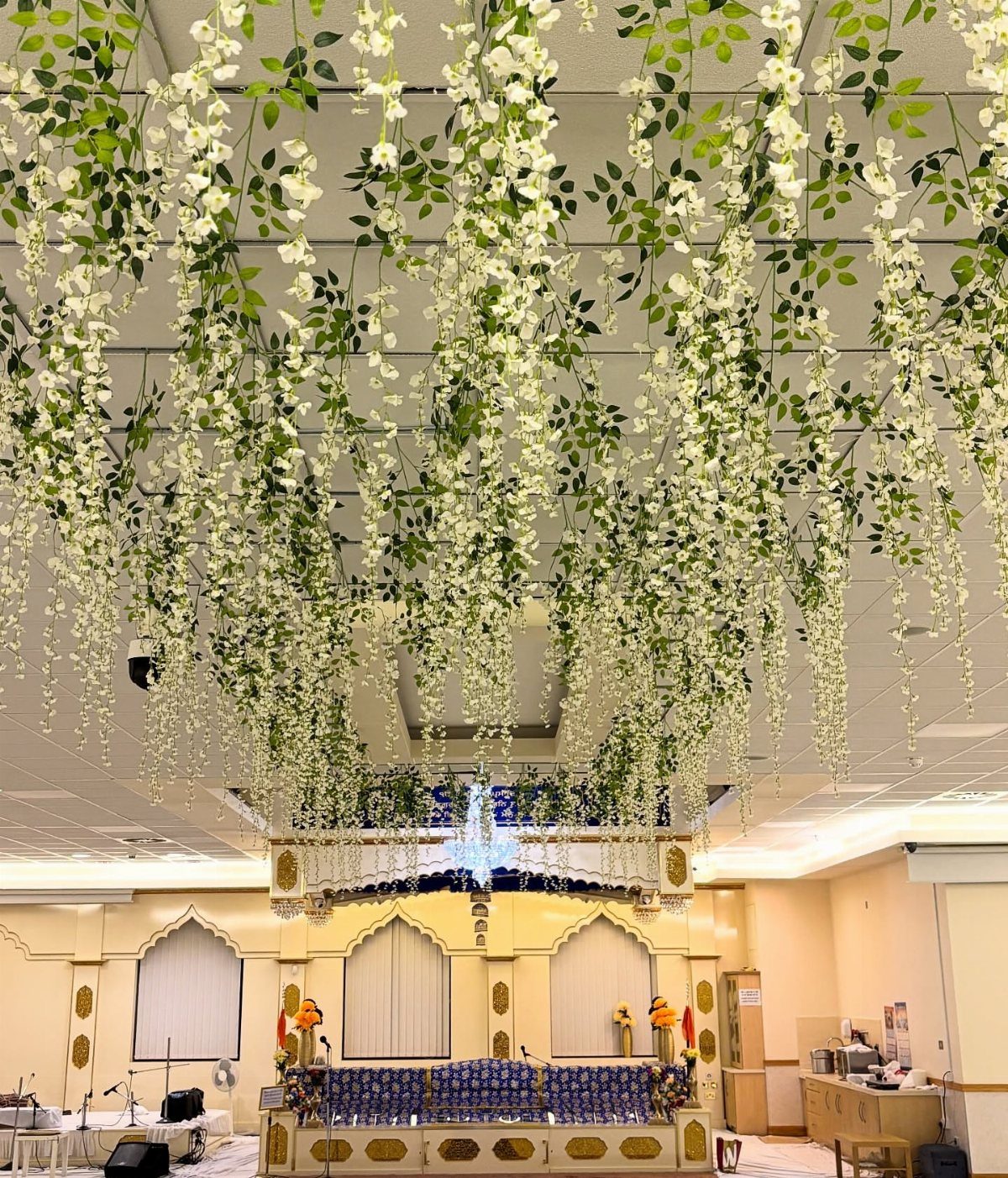 Wedding Flower Trends: 36 Ideas from Jewel Tones to Arches 32 Hanging white wisteria flowers decorating the ceiling of a wedding event hall.