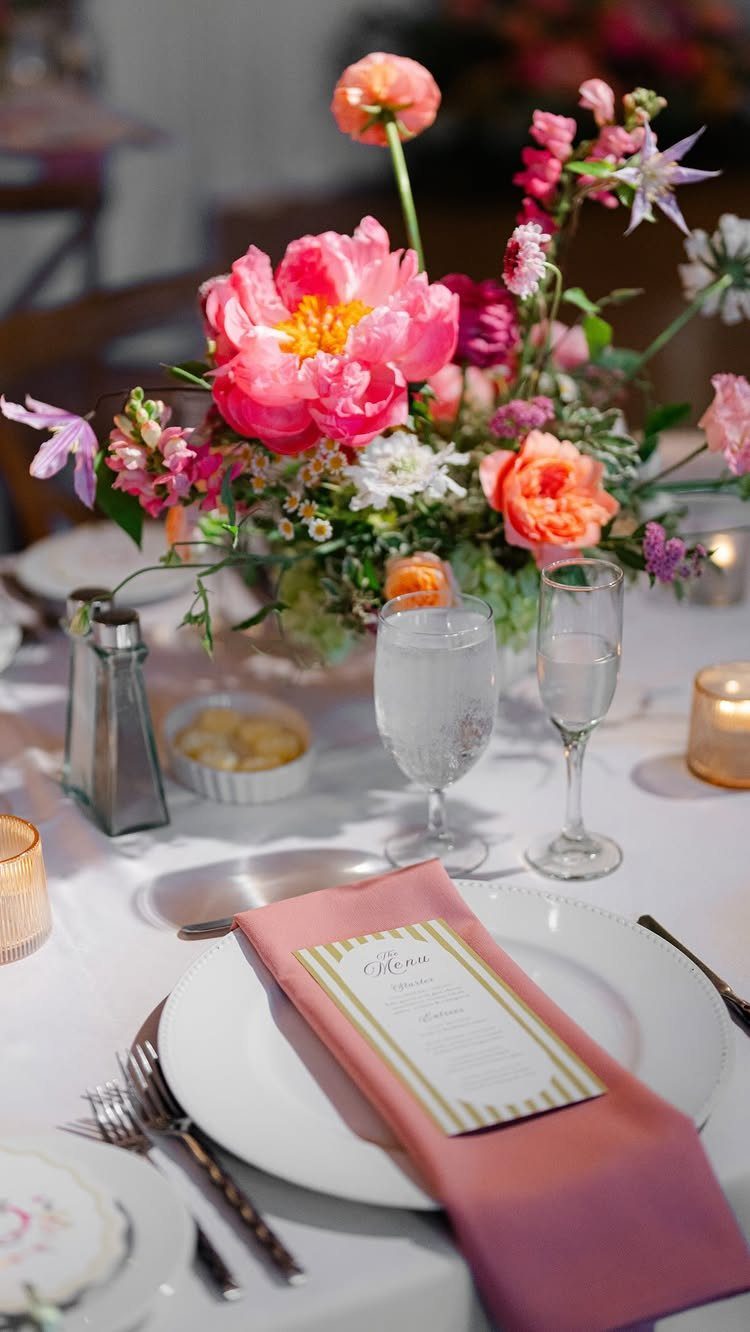 Wedding Flower Trends: 36 Ideas from Jewel Tones to Arches 2 Vibrant pink and orange floral centerpiece on a white wedding table setting.