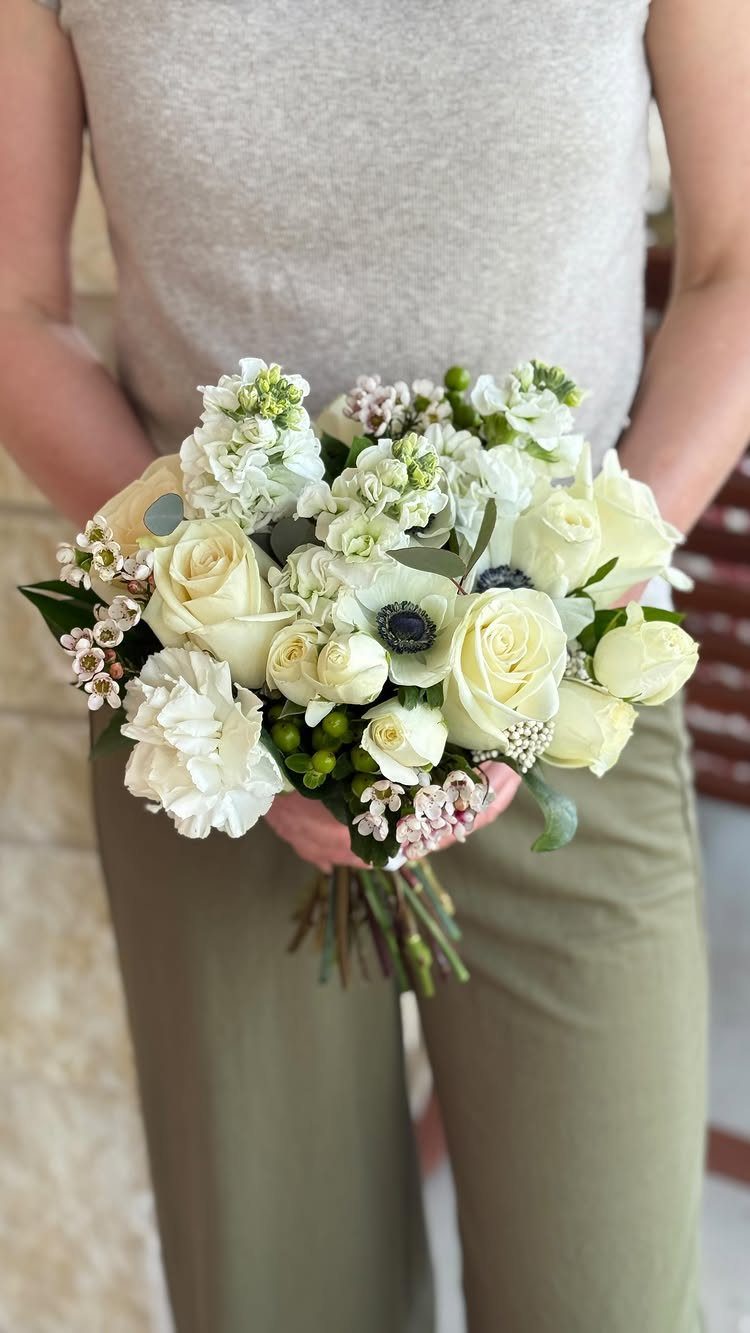 Wedding Flower Trends: 36 Ideas from Jewel Tones to Arches 21 Small round nosegay bouquet of white roses and anemones held by a person.
