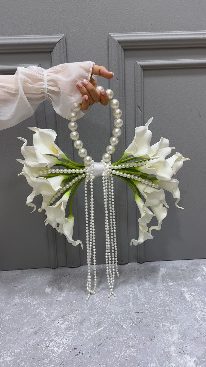 Wedding Flower Trends: 36 Ideas from Jewel Tones to Arches 35 White calla lily bridal bouquet with decorative pearl strings and a pearl handle.