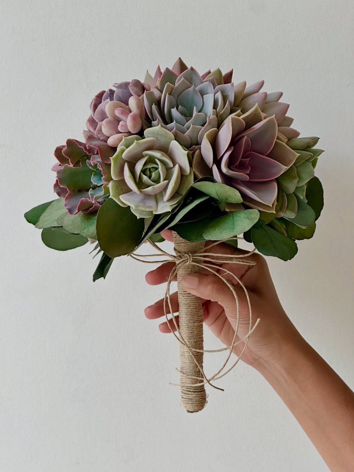 Wedding Flower Trends: 36 Ideas from Jewel Tones to Arches 23 Succulent bridal bouquet in purple and green tones with a twine-wrapped handle.