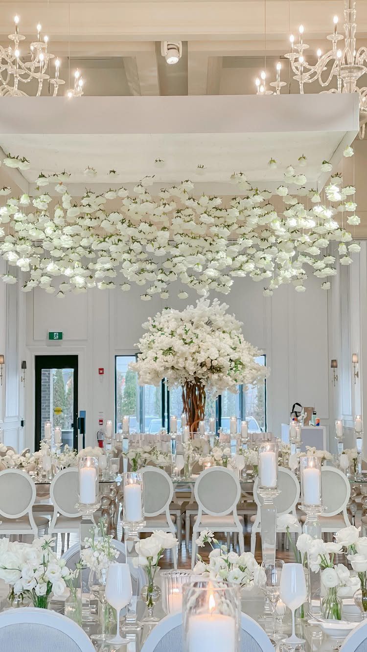 Wedding Flower Trends: 36 Ideas from Jewel Tones to Arches 31 White floral canopy and centerpieces in a bright, elegant wedding reception hall.
