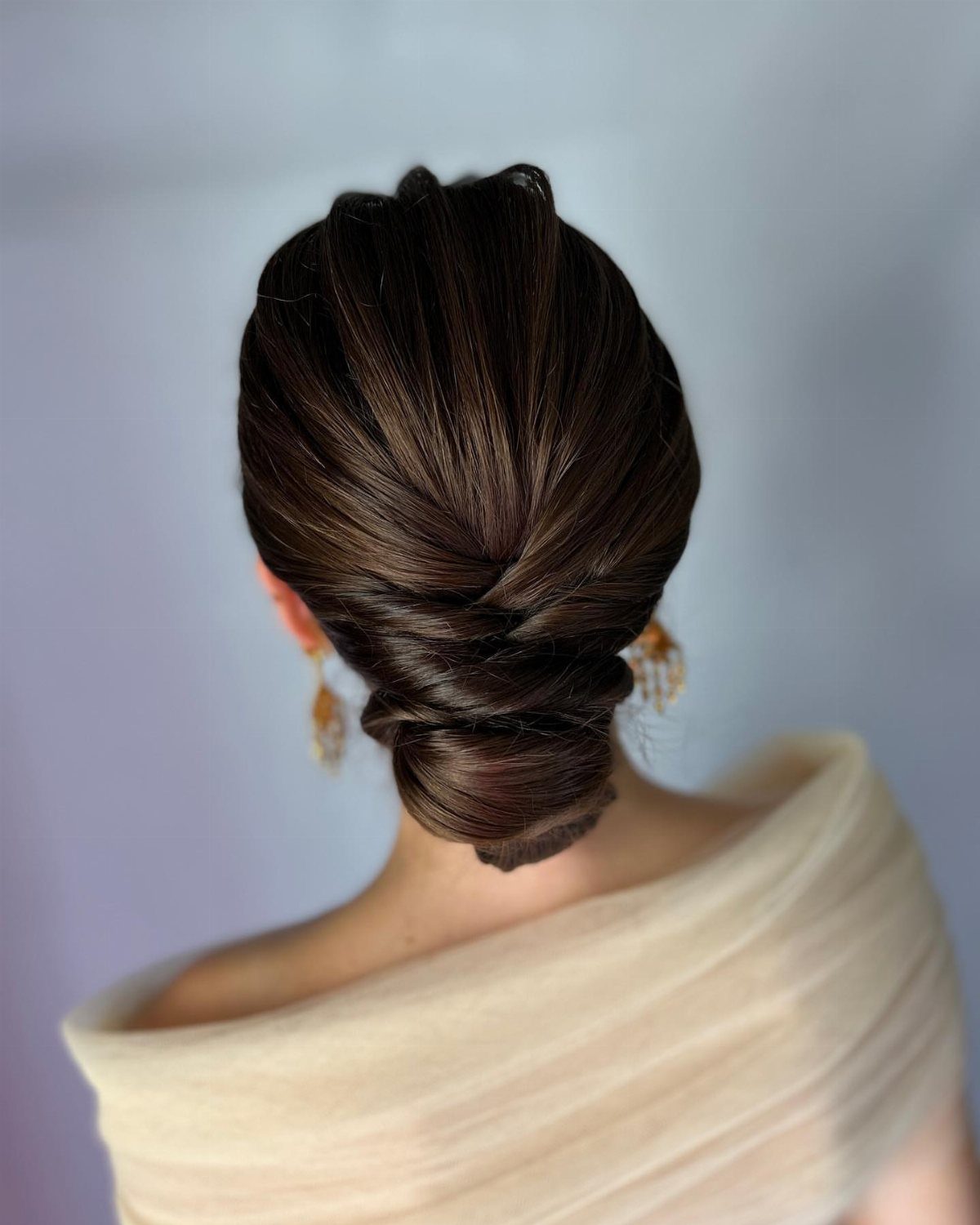Dark brown hair styled in a polished low chignon bun from behind.