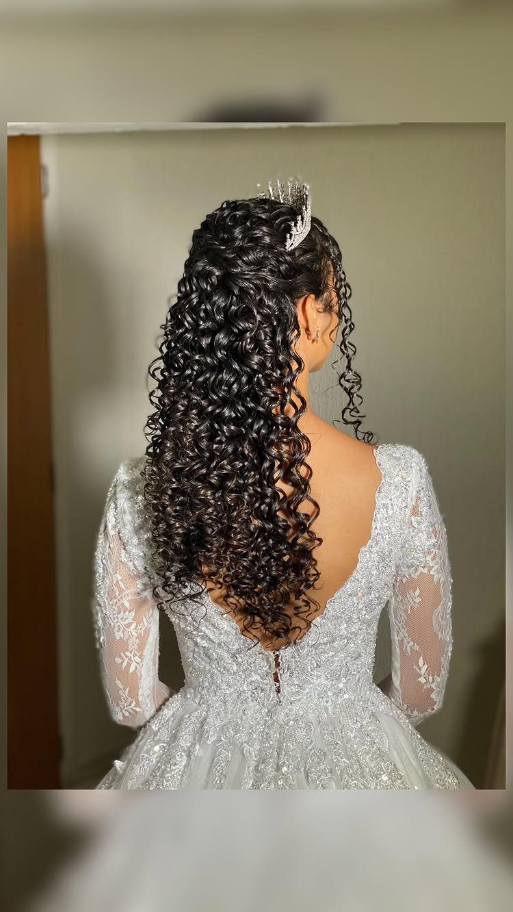Woman with long dark curly hair wearing a white wedding dress and tiara