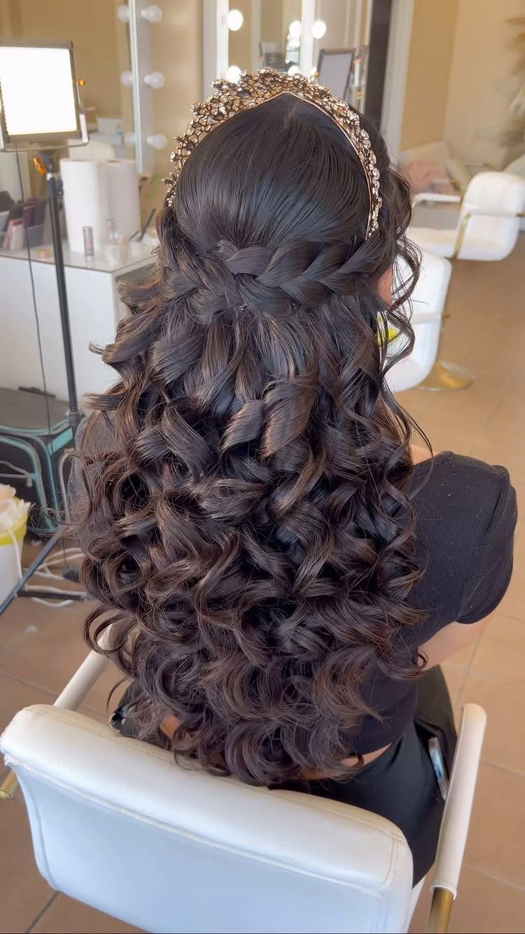 Long dark brown curly hair in a half-up half-down style with a gold headband.