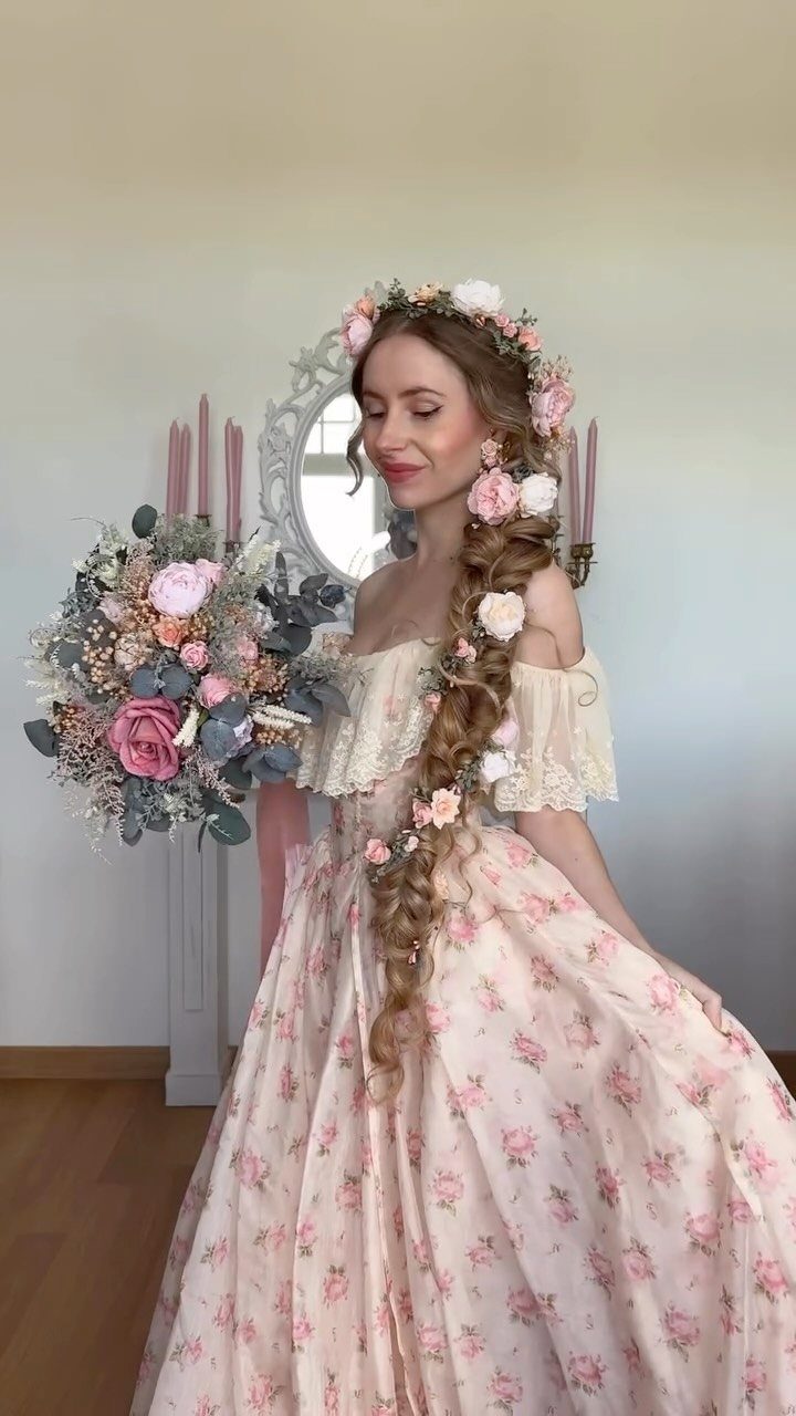 Woman with curly blonde hair in a floral braid wearing a pink gown.