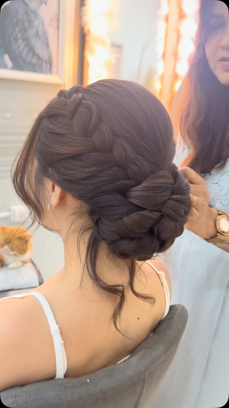 Braided low bun updo on a woman with dark brown medium-length hair.