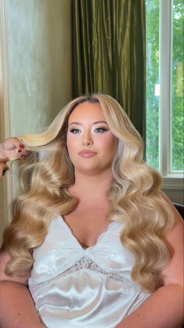 Woman with blonde Hollywood waves hairstyle wearing a white satin dress
