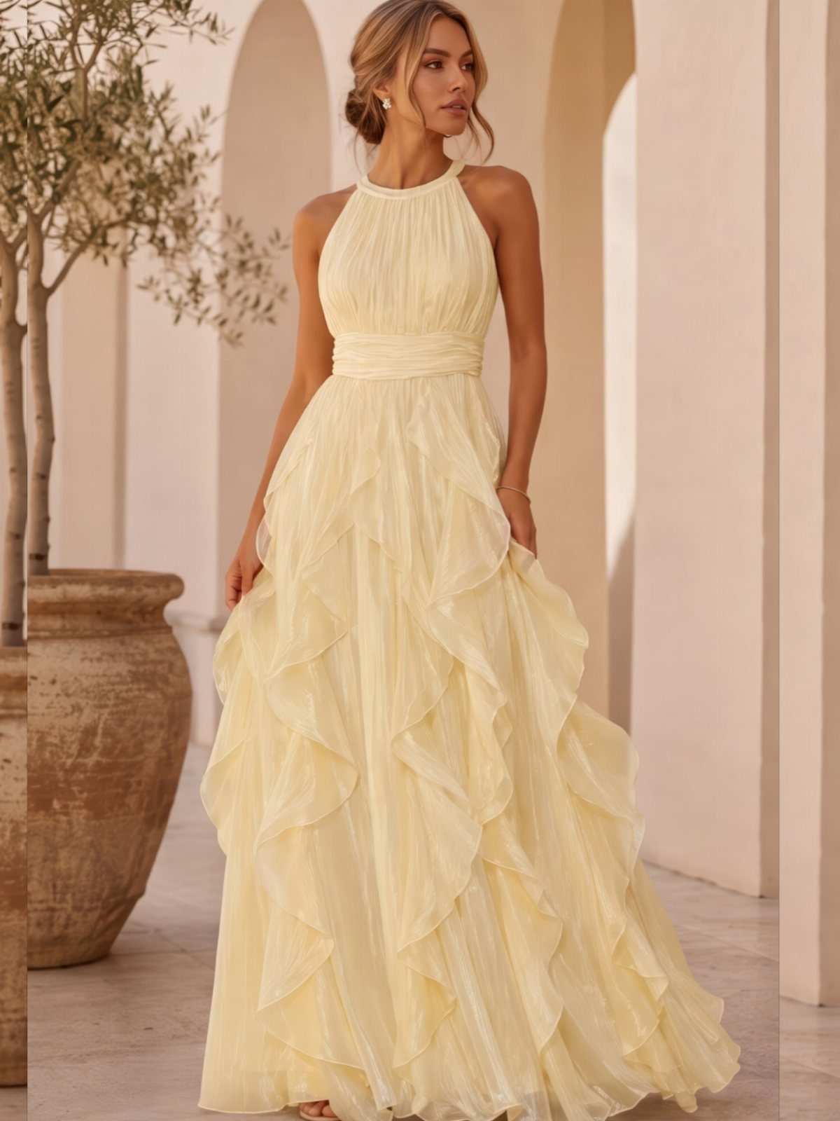 Wedding Outfit Outdoor: 9 Guest Looks for Every Setting 6 Woman in a pale yellow ruffled halter-neck maxi dress standing near arched architecture.