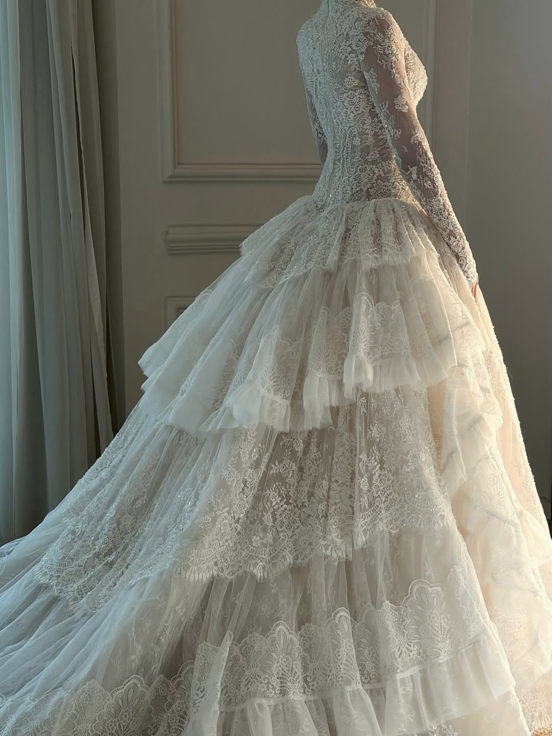 18 Wedding Outfit Theme Ideas for 2026: Beach, Boho, Gatsby & More 3 Lace wedding gown with long sleeves and a voluminous tiered tulle skirt.