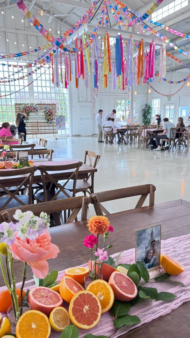 Wedding Party Colors: 13 Real Palette Ideas for Your Bridal Party 3 Citrus fruit centerpieces and colorful streamers decorate a bright wedding reception venue with wooden tables.