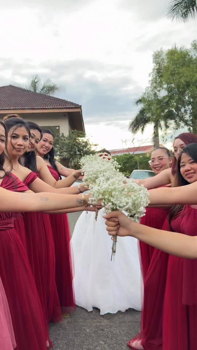 Wedding Party Colors: 13 Real Palette Ideas for Your Bridal Party 11 Bridesmaids in red dresses holding white flower bouquets around a bride in a white gown.
