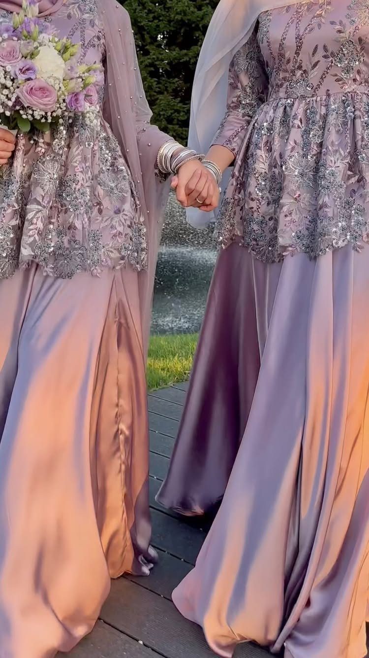 Wedding Party Colors: 13 Real Palette Ideas for Your Bridal Party 14 Two women in matching lavender embroidered gowns holding hands and a flower bouquet.