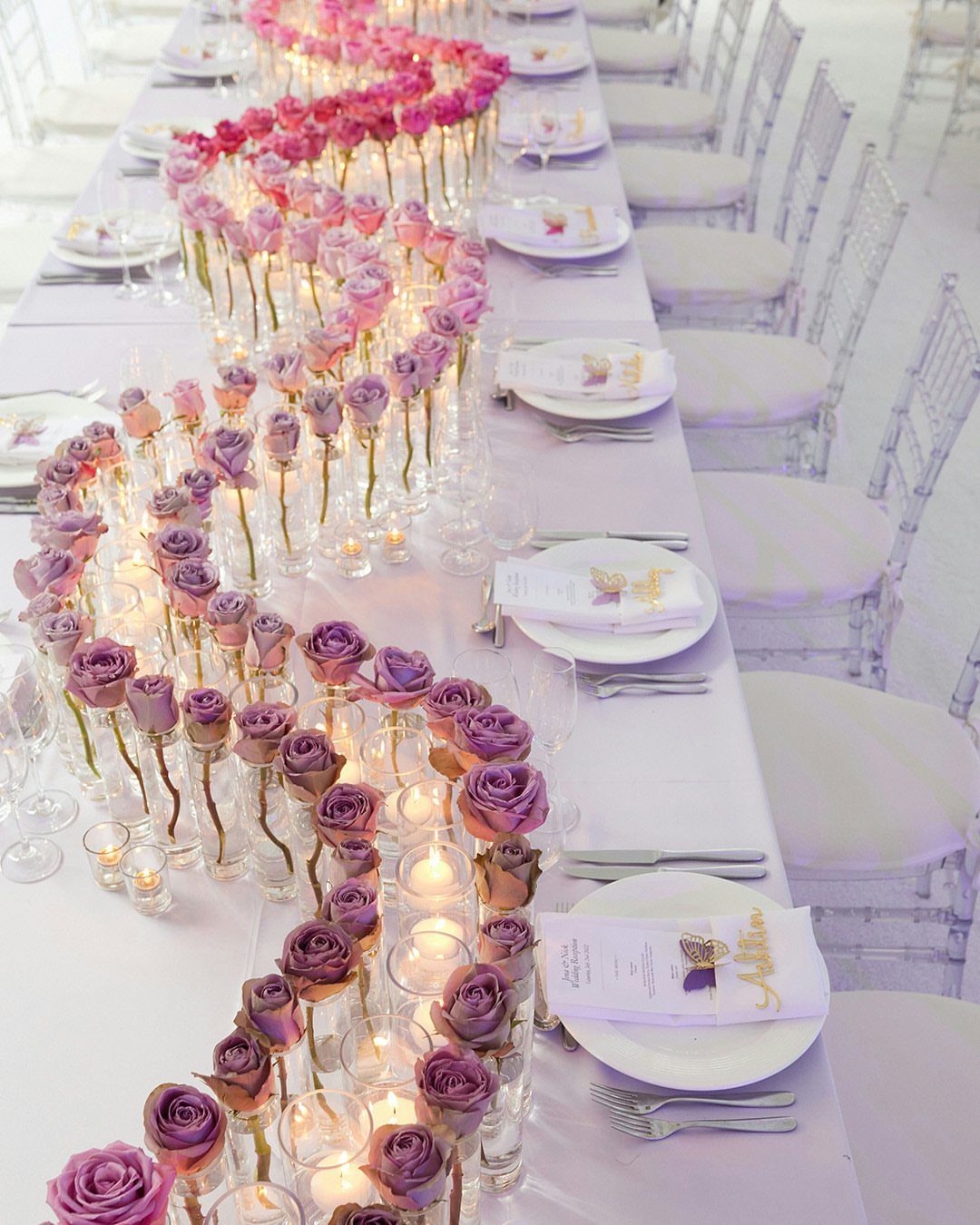 Wedding Party Colors: 13 Real Palette Ideas for Your Bridal Party 5 Pink and purple roses arranged in a winding ombre pattern down a long wedding table.