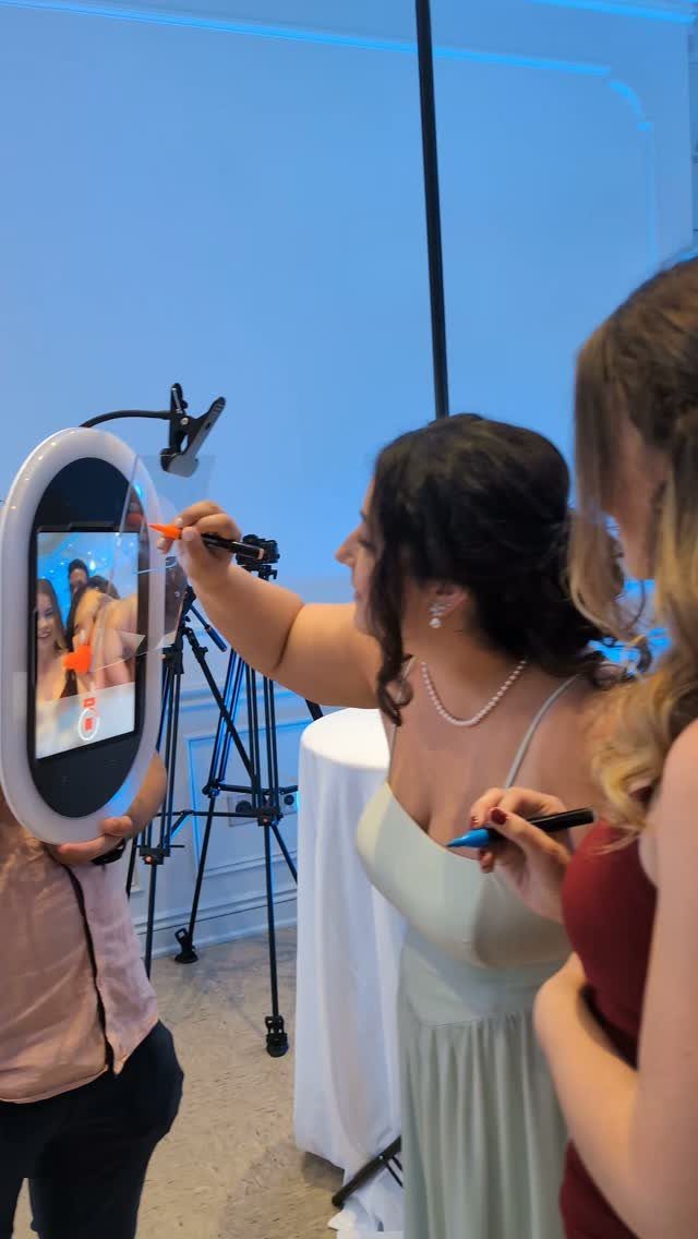 10 Wedding Party Ideas for an Unforgettable Night 2 A woman writing on a circular digital screen that displays a photo during an event.