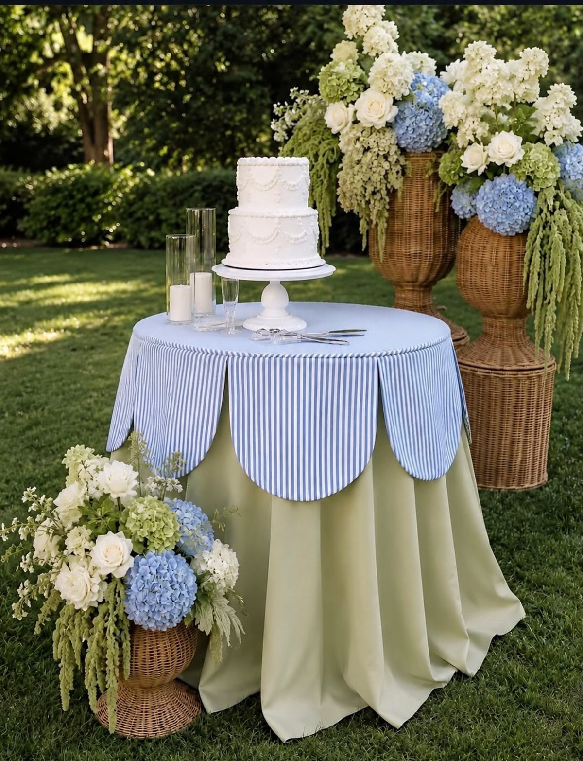 White wedding cake on a table with sage green and blue striped linens.
