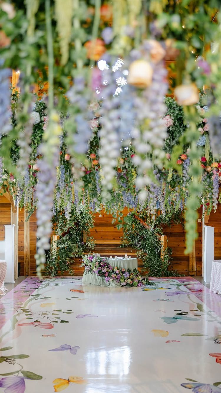 25 Wedding Stuff Ideas for Your 2026 Ceremony and Party 8 Cascading lavender and peach floral installations hanging over a white butterfly-patterned dance floor.