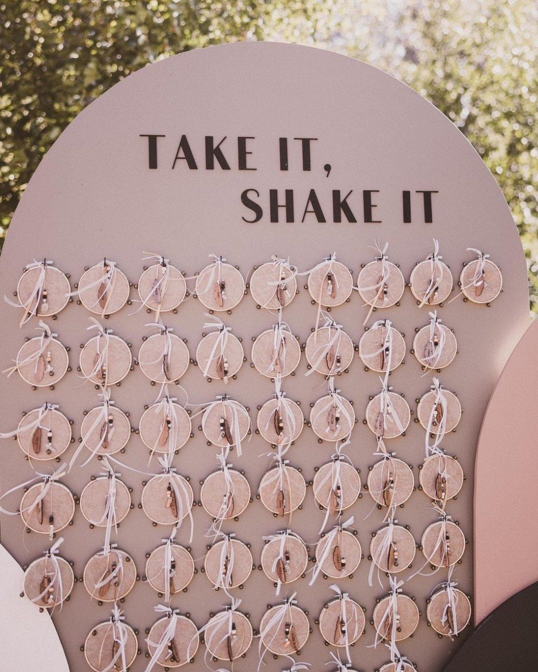 25 Wedding Stuff Ideas for Your 2026 Ceremony and Party 25 Wooden discs with white strings attached to a pink sign reading Take It, Shake It.