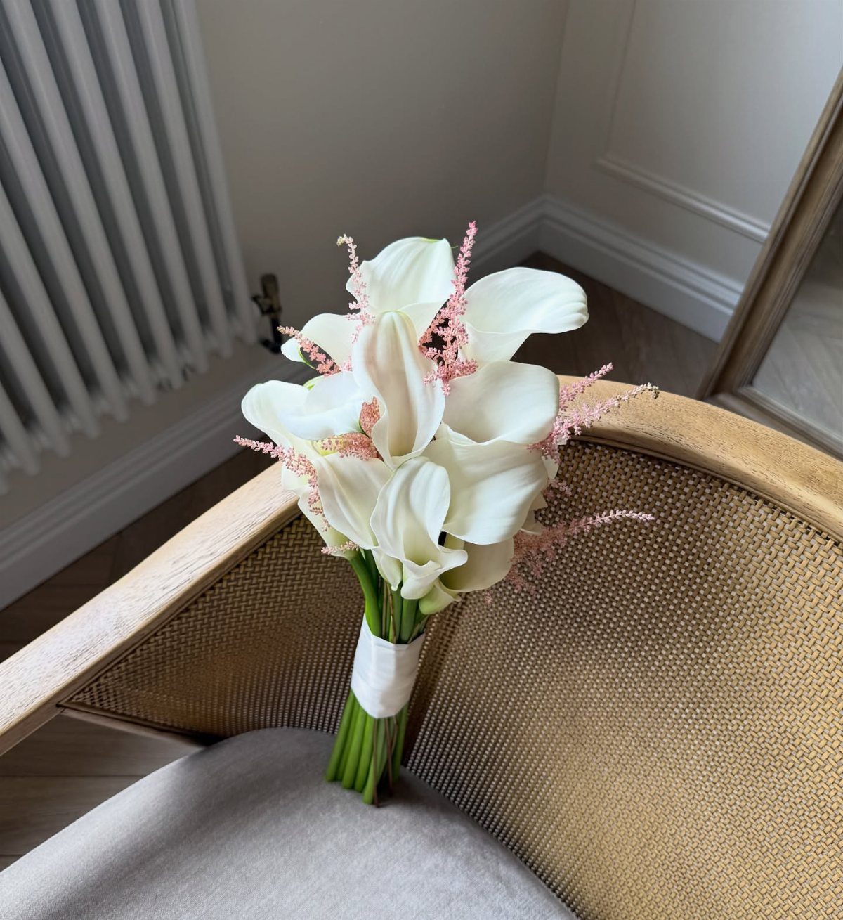 Wedding Theme Flowers: 21 Ideas for Ceremony to Cake 6 White calla lilies with pink accents wrapped in white ribbon on a chair.