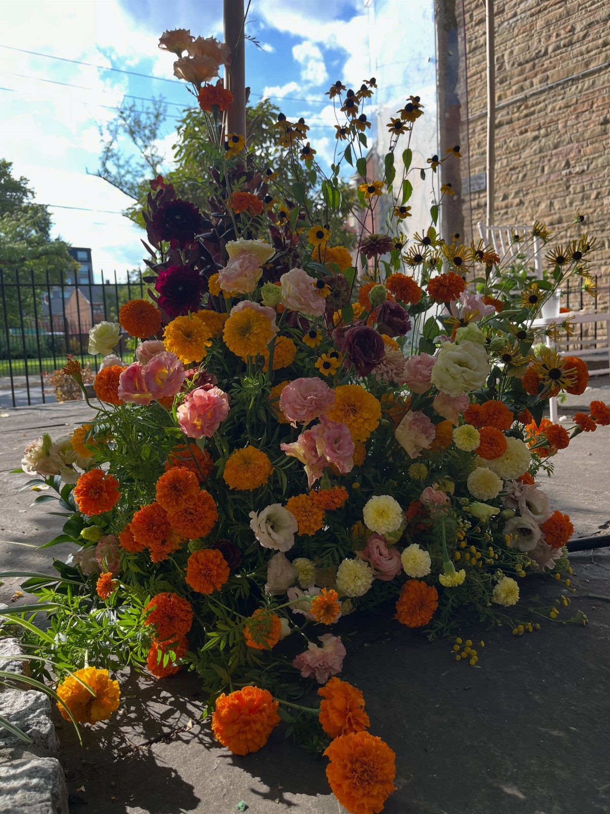 Wedding Theme Flowers: 21 Ideas for Ceremony to Cake 14 Vibrant orange marigolds and pink ranunculus arranged in a lush floral display outdoors.