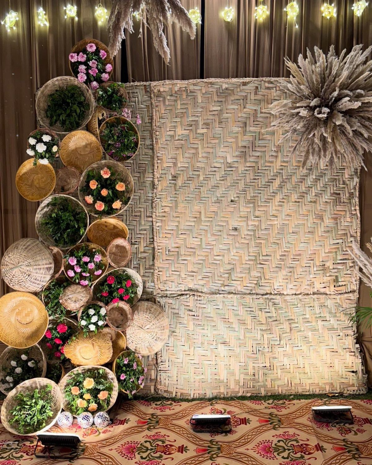Wedding Theme and Motif: 16 Fresh Ideas for 2026 9 Woven baskets filled with colorful flowers arranged against straw mats and fairy lights.