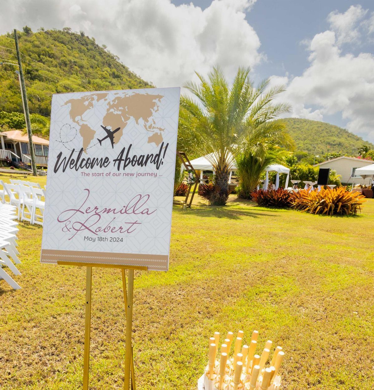 Wedding Theme and Motif: 16 Fresh Ideas for 2026 12 A wedding welcome sign with a world map and airplane icon on a grassy lawn.