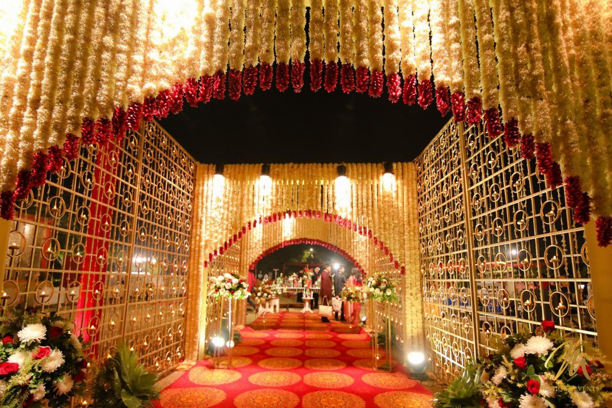 Wedding Theme and Motif: 16 Fresh Ideas for 2026 3 A red carpet walkway leading through a grand floral archway with golden lattice gates.