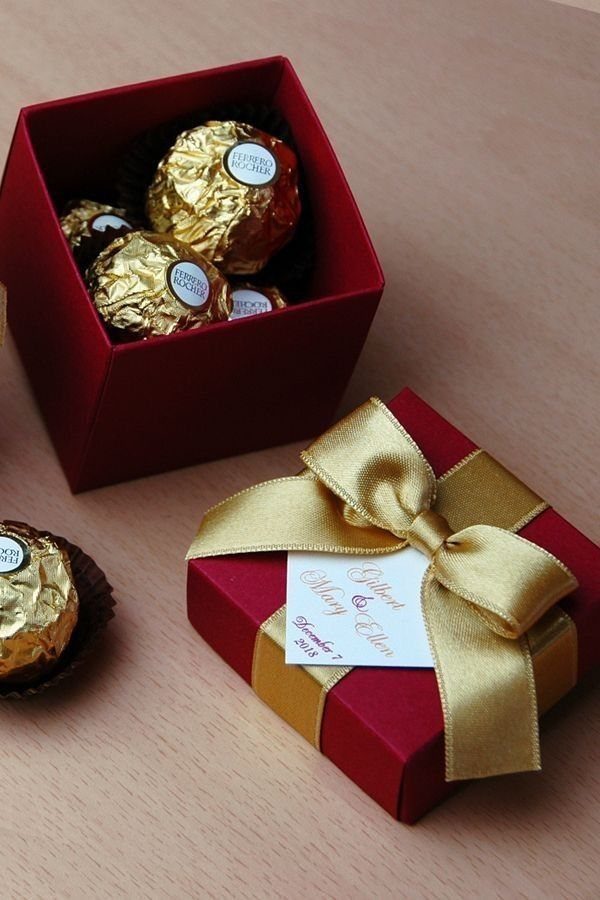 8 Wedding Theme Red and Gold Ideas for Every Part of Your Day 6 Red gift boxes filled with gold wrapped chocolates and decorated with gold ribbons.