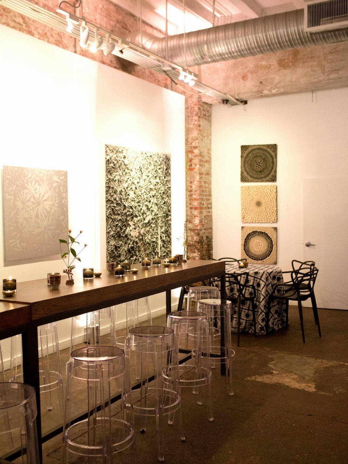 Wedding Themes 2026: 12 Ideas You Will Actually Want to Steal 5 Clear acrylic stools line a long wooden table in a modern art gallery setting.