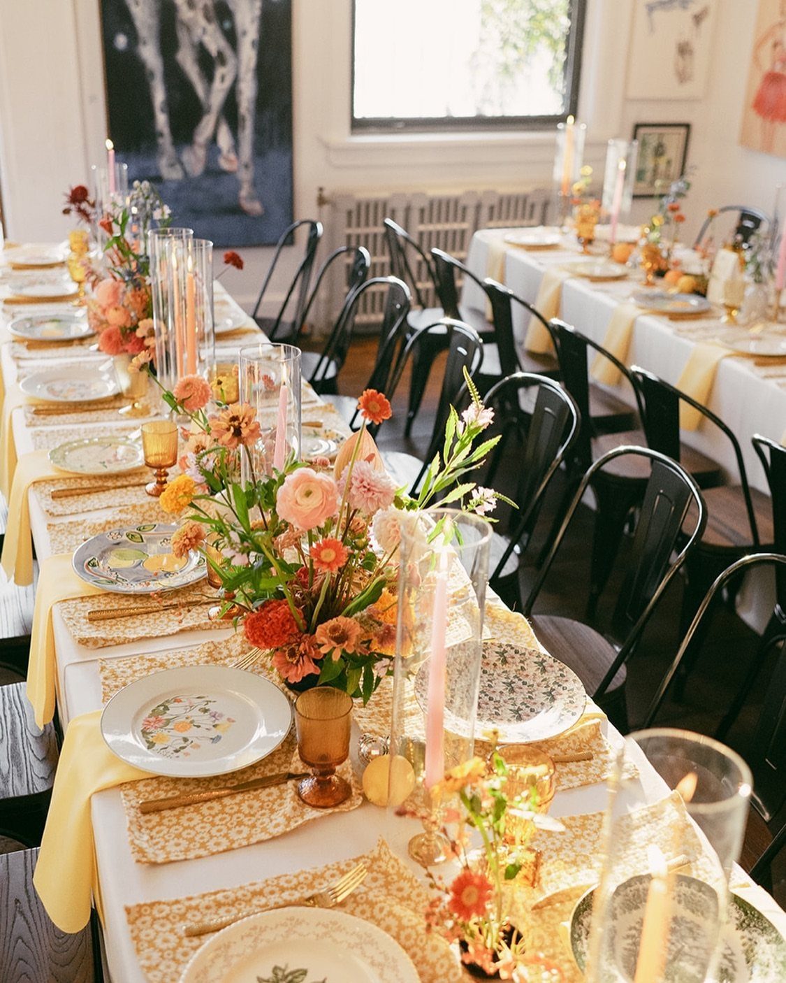 Wedding Themes 2026: 12 Ideas You Will Actually Want to Steal 8 A long wedding reception table featuring mismatched patterned plates, amber glasses, and colorful floral arrangements.