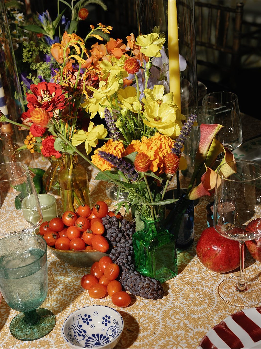 Wedding Themes 2026: 12 Ideas You Will Actually Want to Steal 12 Colorful floral arrangements, fresh fruits, and glassware set on a patterned yellow tablecloth.