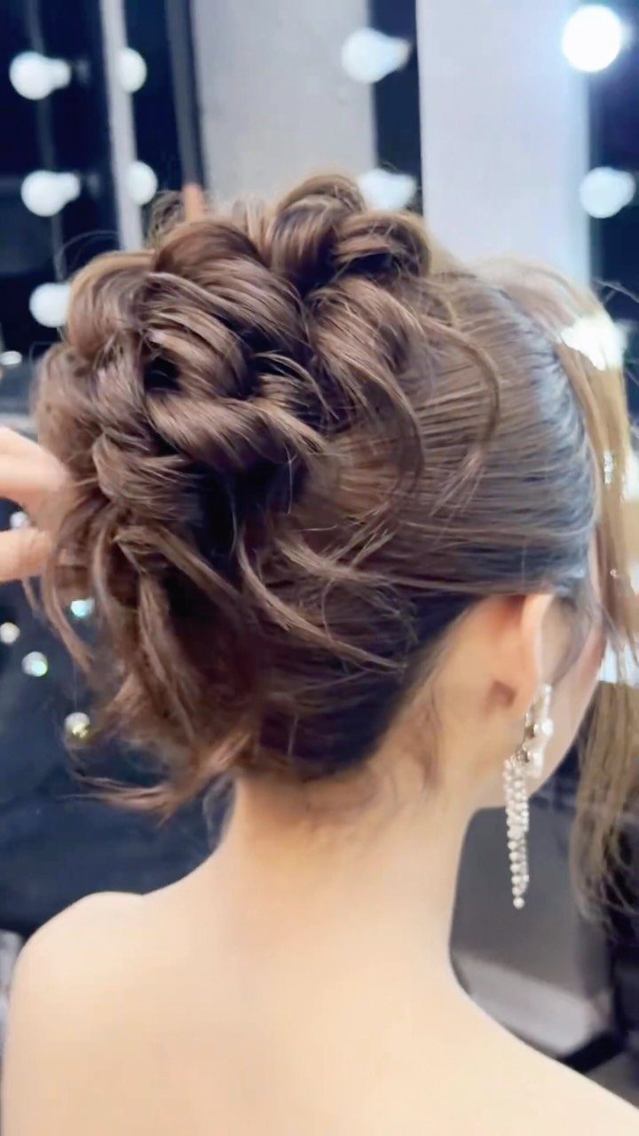 27 Bridesmaid Wedding Updo Hairstyles from Buns to Braids 3 Intricate brown braided updo with curls and a sparkling silver earring.