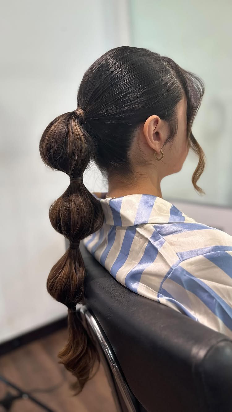 27 Bridesmaid Wedding Updo Hairstyles from Buns to Braids 6 Bubble ponytail with rounded sections on a woman wearing a striped shirt.