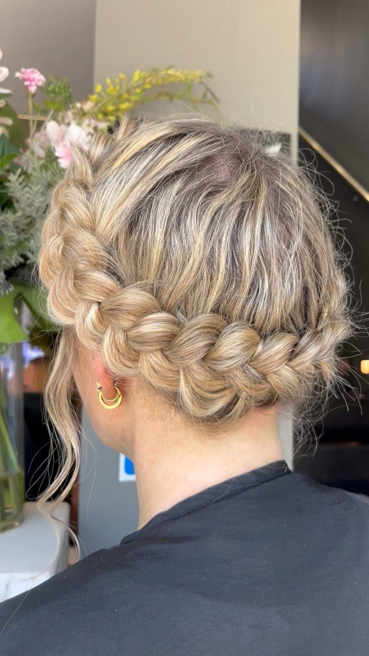 27 Bridesmaid Wedding Updo Hairstyles from Buns to Braids 27 Blonde hair styled in a thick crown braid updo with loose face-framing strands.