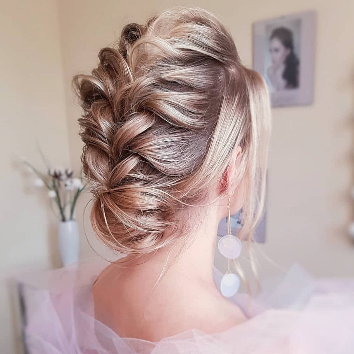 27 Bridesmaid Wedding Updo Hairstyles from Buns to Braids 21 Blonde woman with a French braid updo and low bun wearing pink tulle.