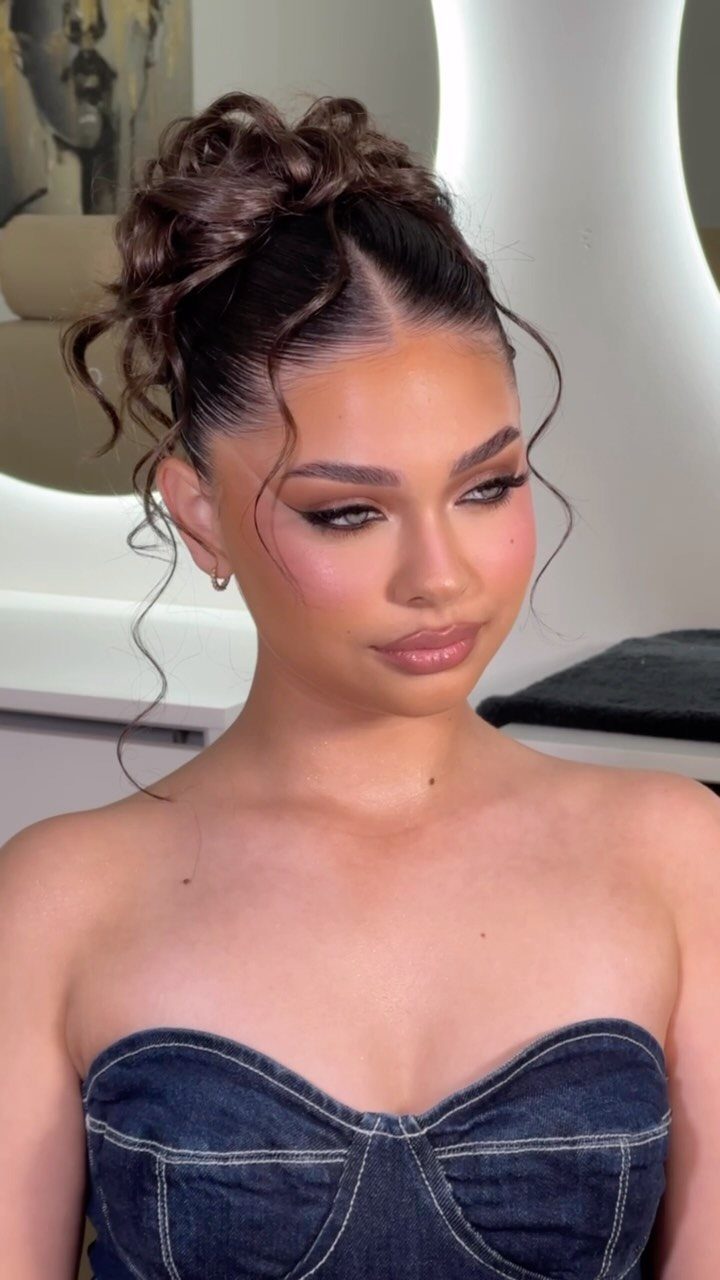 27 Bridesmaid Wedding Updo Hairstyles from Buns to Braids 28 Woman with a high voluminous brown hair updo and loose face-framing curls.