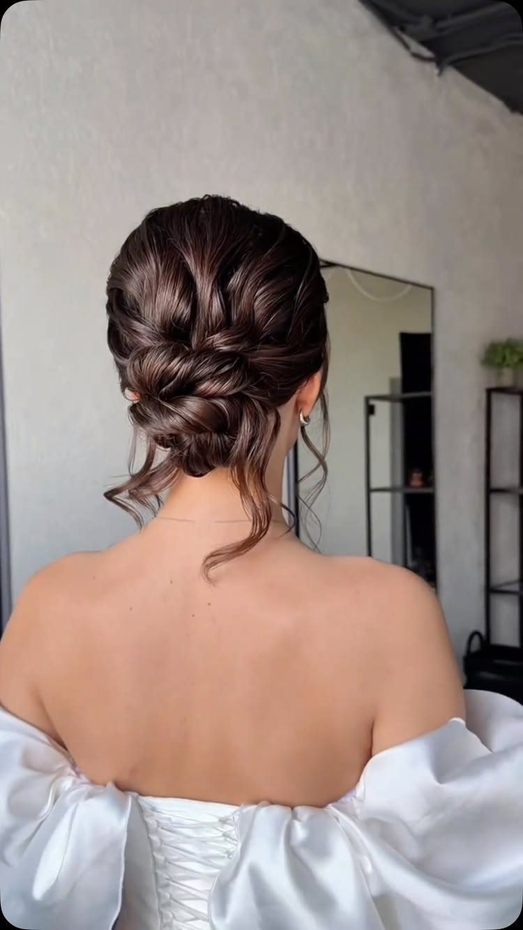27 Bridesmaid Wedding Updo Hairstyles from Buns to Braids 2 Woman with brown hair in a low textured bun and white dress