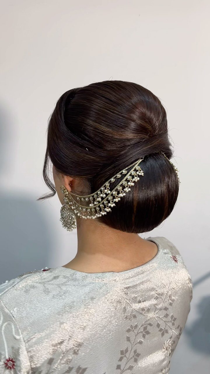 27 Bridesmaid Wedding Updo Hairstyles from Buns to Braids 7 Smooth low bun hairstyle with a gold and pearl decorative hair accessory.