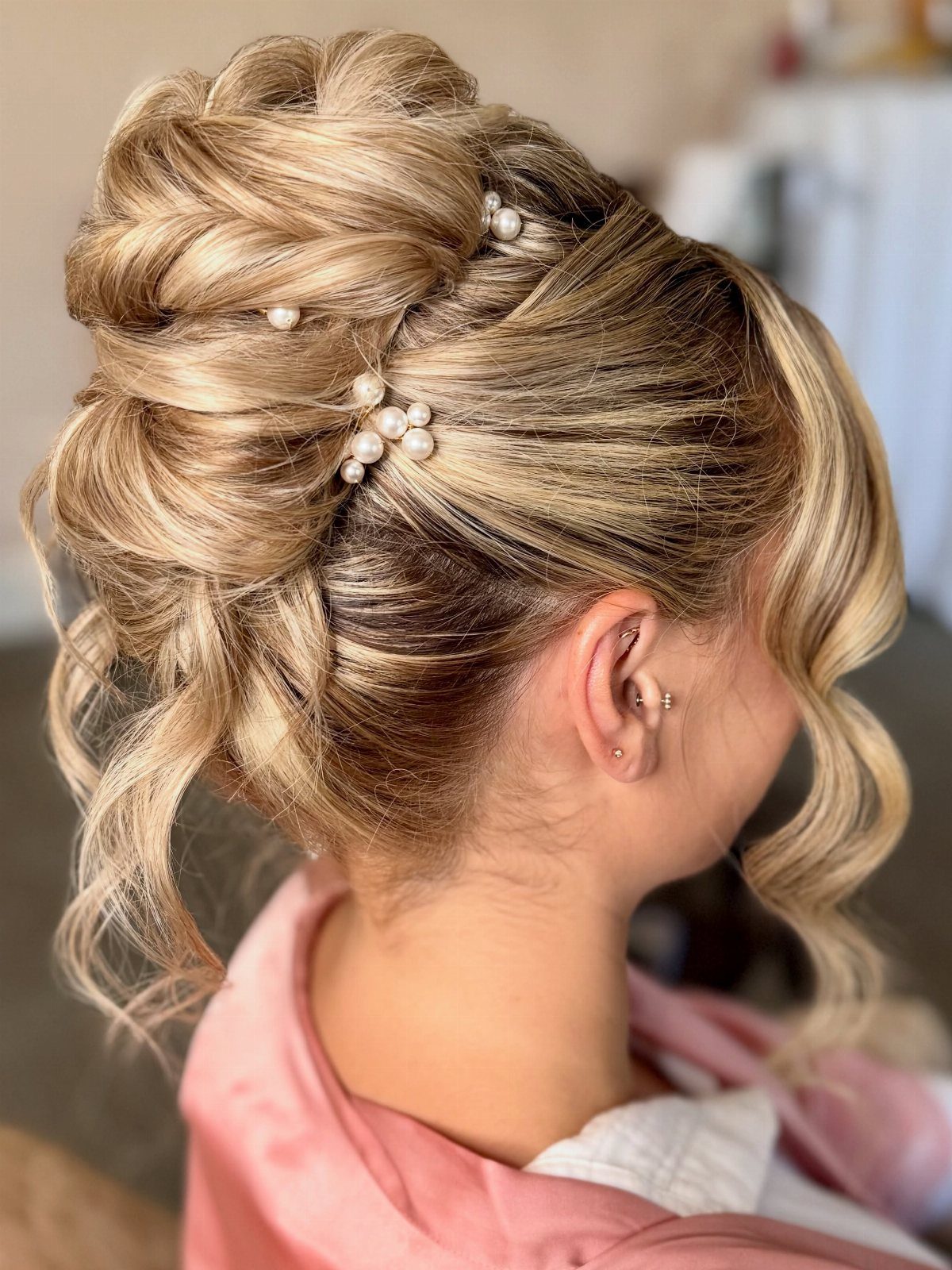 27 Bridesmaid Wedding Updo Hairstyles from Buns to Braids 15 Blonde voluminous updo with pearl pins and curled face-framing strands of hair.
