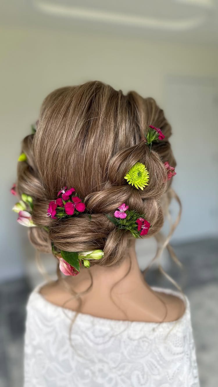 27 Bridesmaid Wedding Updo Hairstyles from Buns to Braids 19 Low twisted updo with pink and yellow flowers in light brown hair