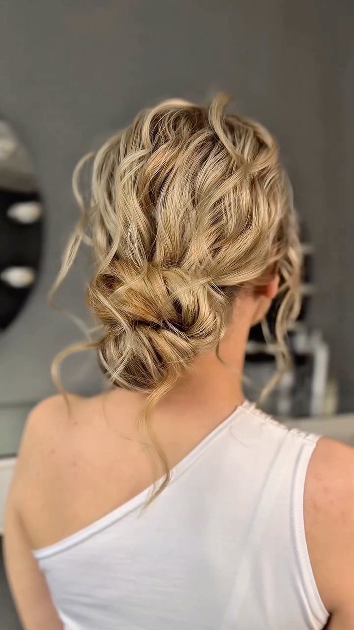 Wedding Updo Low Bun: How to Style 17 Beautiful Ideas 10 Blonde curly low bun with loose wavy strands and a white top.
