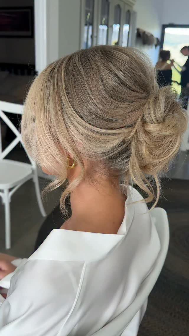Wedding Updo Low Bun: How to Style 17 Beautiful Ideas 4 Blonde hair styled in a messy low bun with soft, curled face-framing strands.