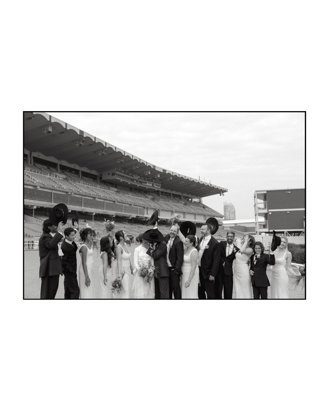 What Are the Best Western Themed Wedding Ideas? 37 Here 6 Wedding party posing in formal attire and cowboy hats before a large stadium.