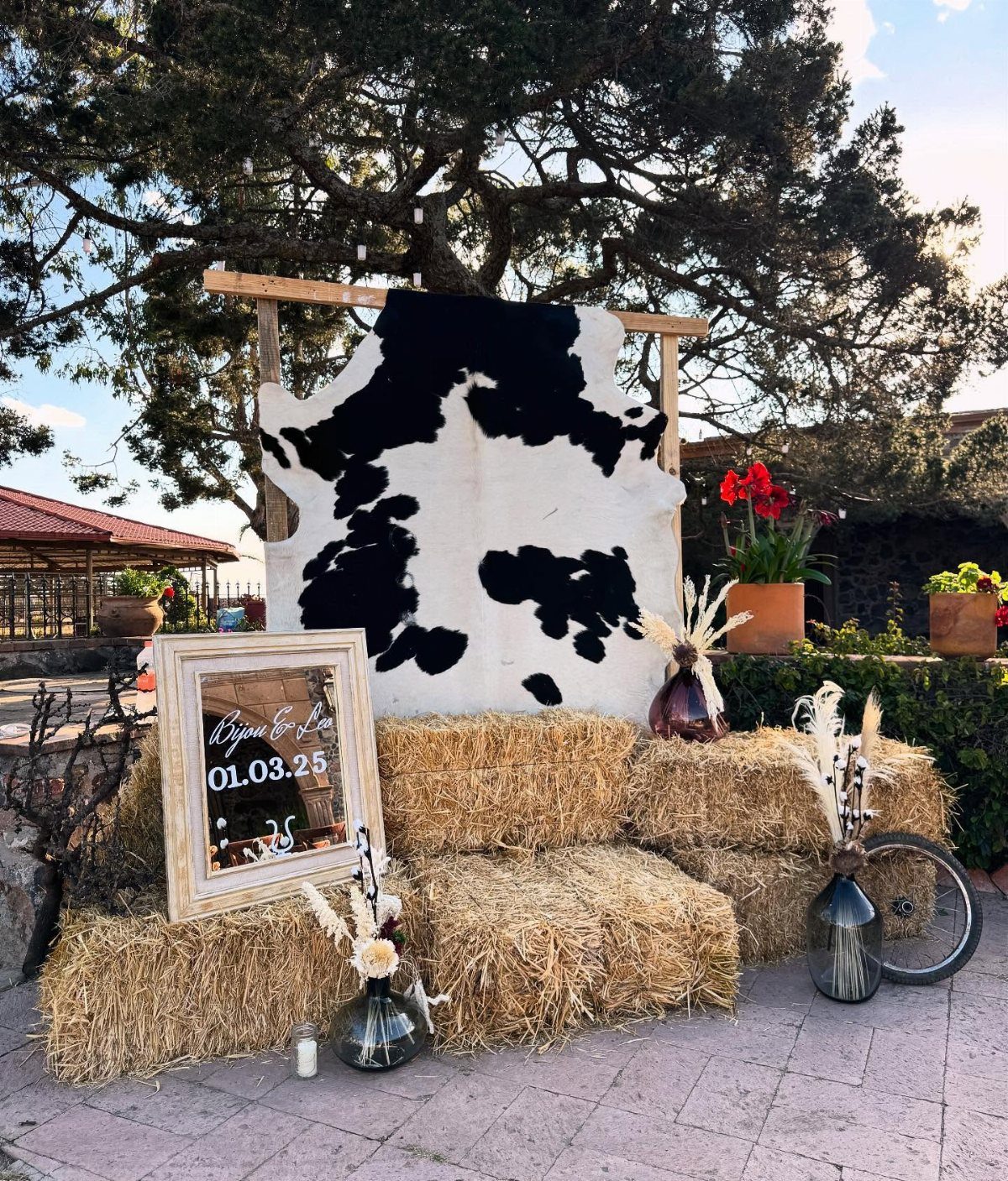 What Are the Best Western Themed Wedding Ideas? 37 Here 3 Black and white cowhide backdrop with hay bales and a wedding date sign.