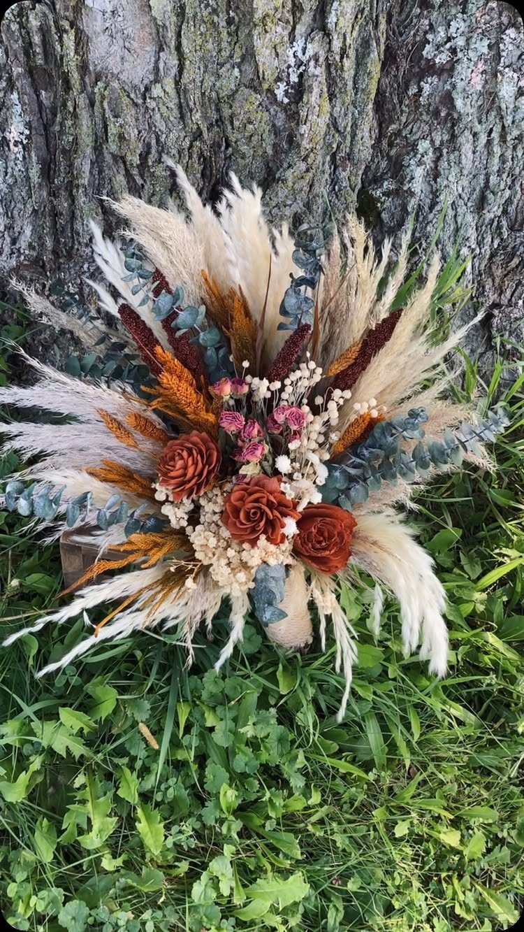 What Are the Best Western Themed Wedding Ideas? 37 Here 37 Rustic bridal bouquet with pampas grass and dried flowers against a tree trunk.